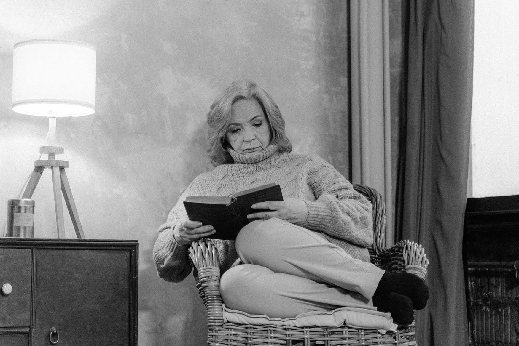 Abuela leyendo un libro en su casa