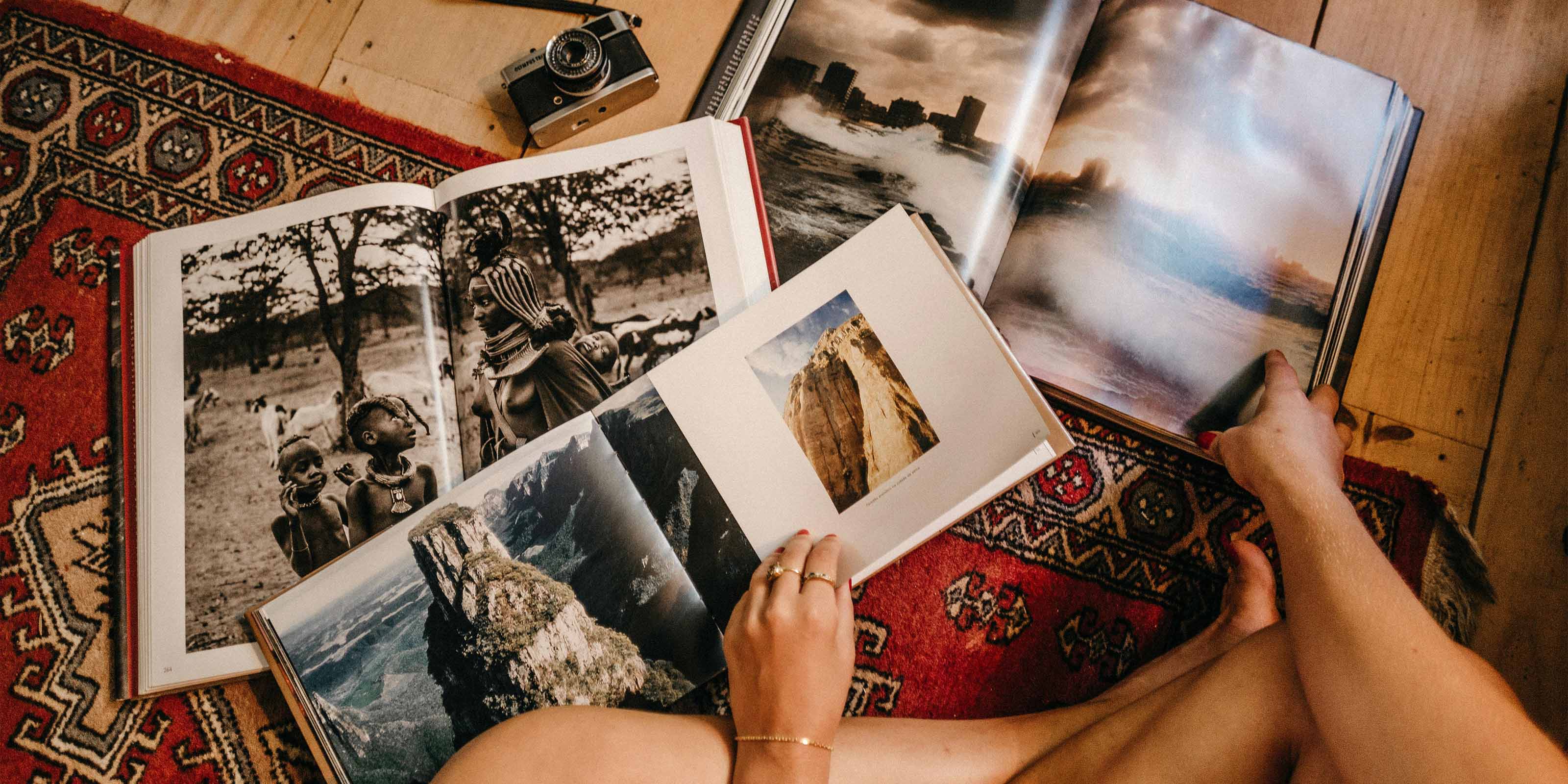 3 álbumes de fotos y una cámara reflex en el suelo.