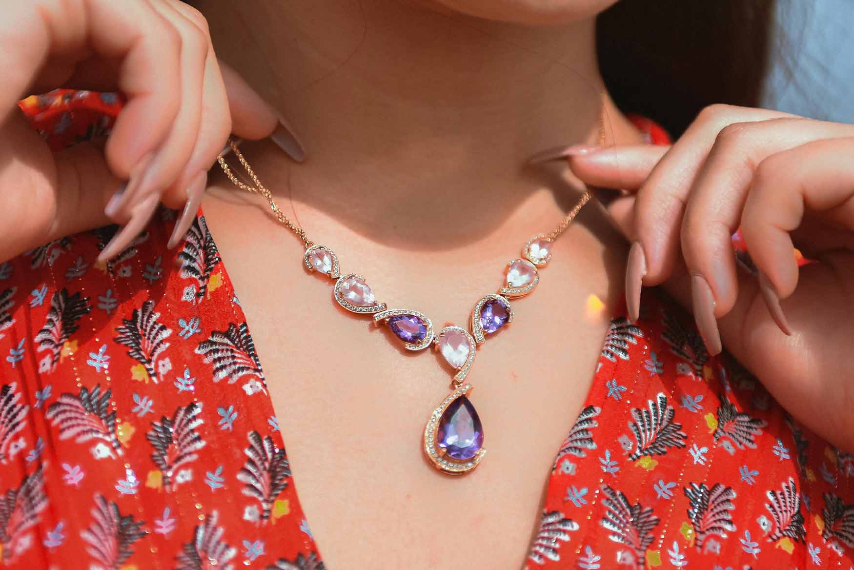 Mujer con collar de cristales morados y transparentes.