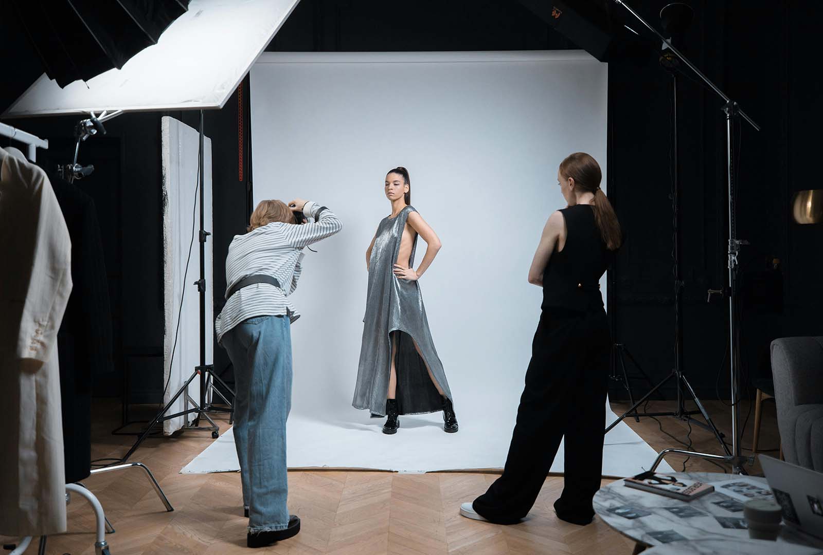 Modelo con vestido plata posando para fotografía de moda en un estudio.