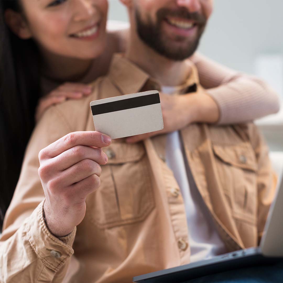 Hombre sostiene una tarjeta, mientras una mujer lo abraza.
