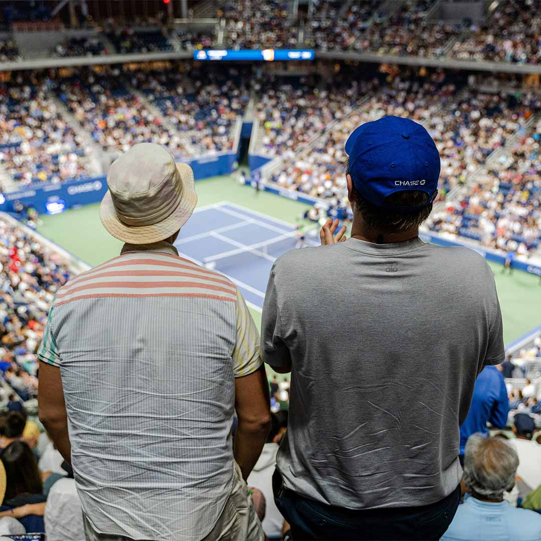 Dos hombres viendo un partido de tenis.