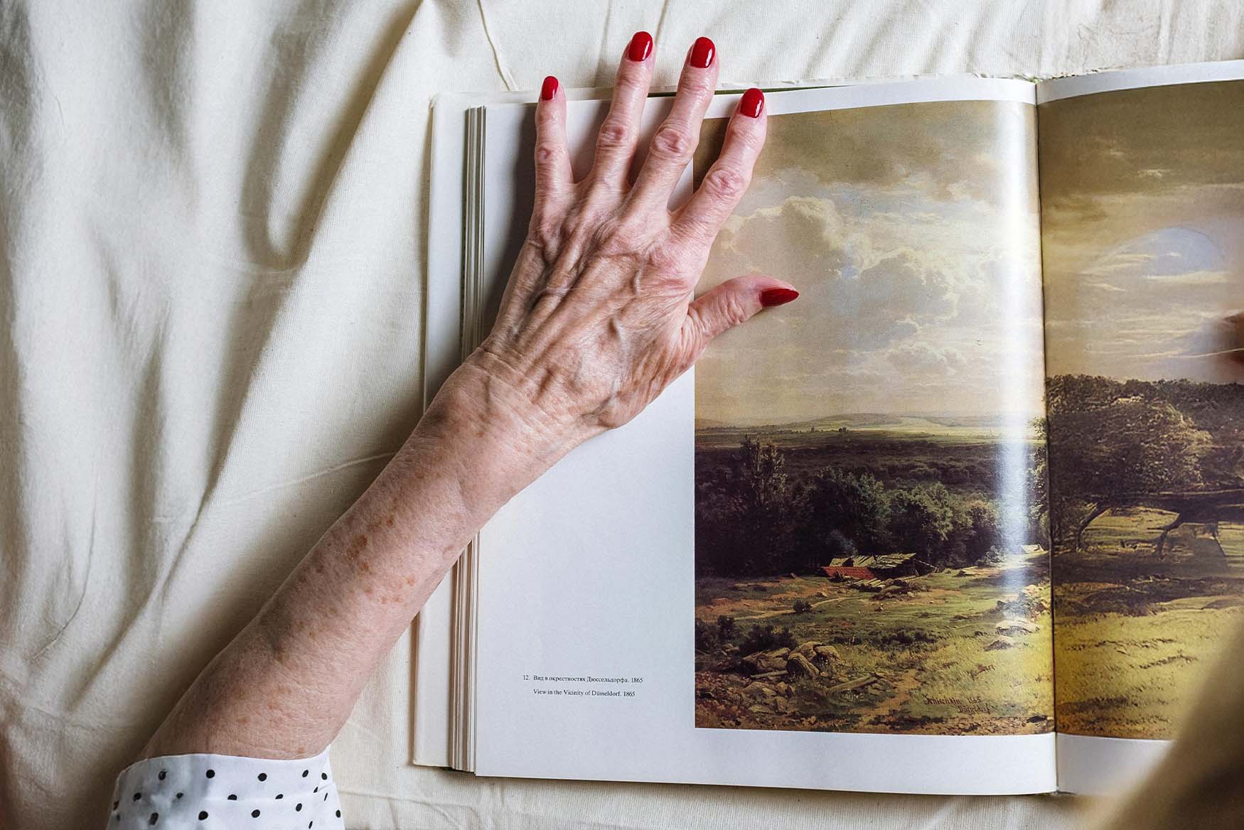 Mano de una abuela sobre una página de fotolibro