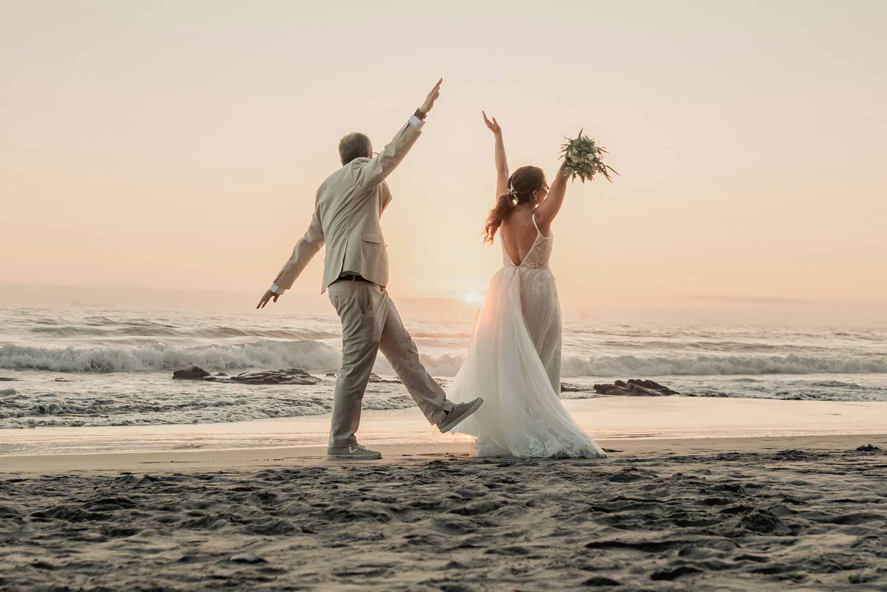 Novios caminando en la playa.
