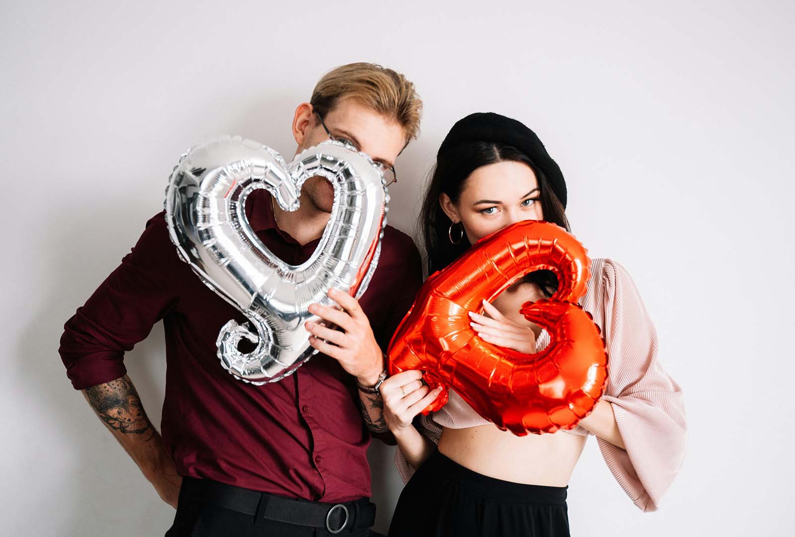 Fotografía en estudio de una pareja con globos de corazón.
