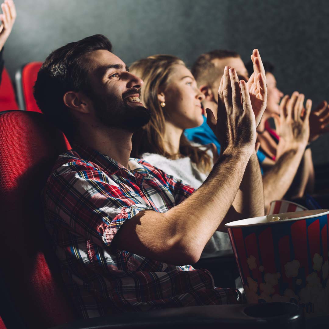 Personas aplaudiendo en un cine.
