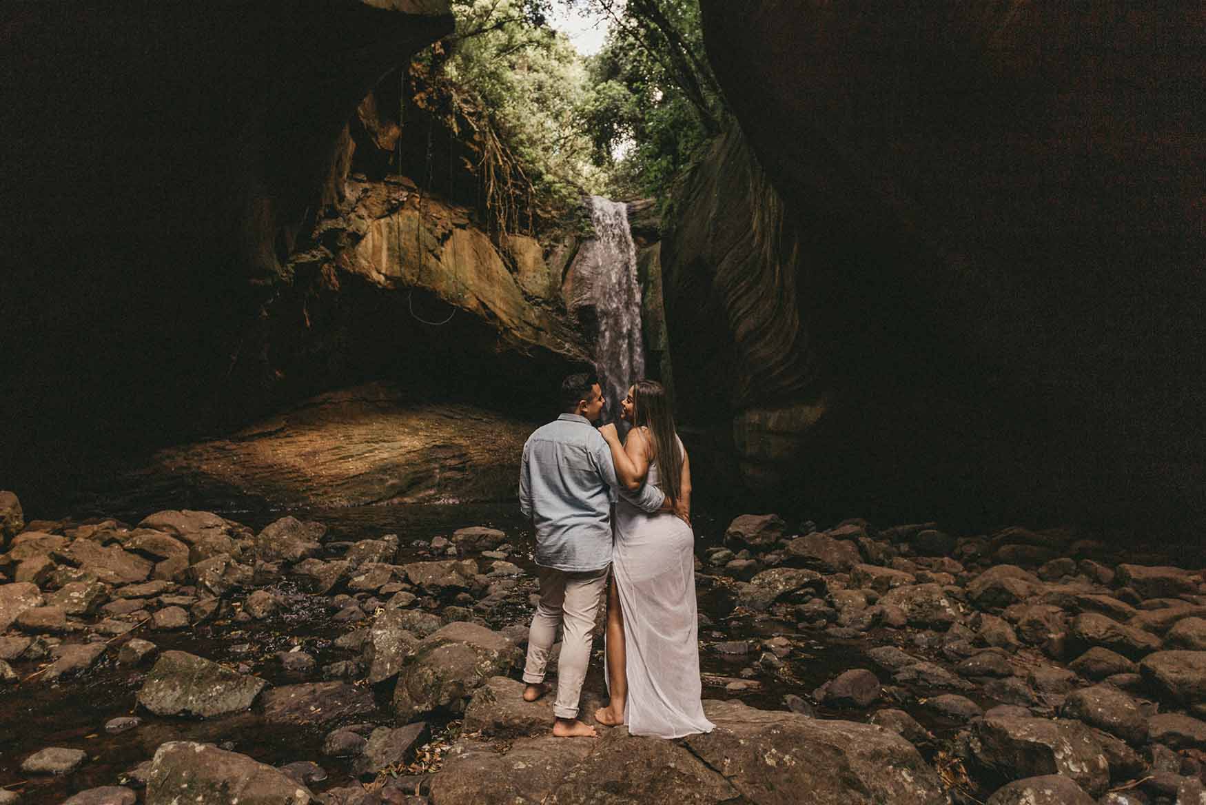 Viaje en pareja en paisaje con cascada.