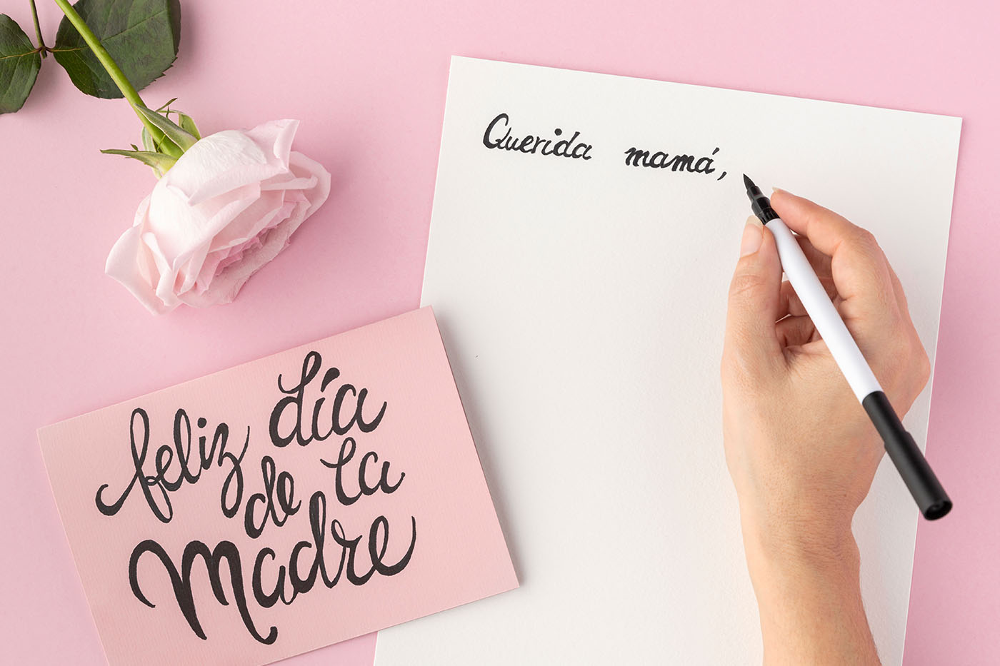 Mano escribiendo una carta para mamá.