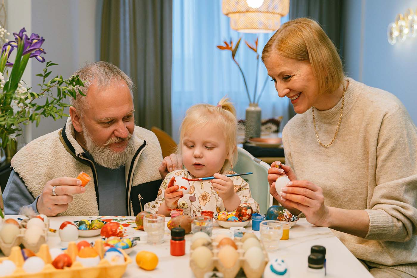 Abuelos con su nieta pintando huevos de pascua (portada)