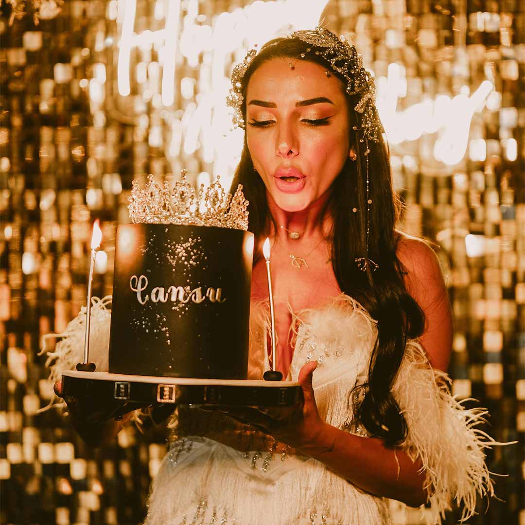 Mujer sopla las velas de un pastel de cumpleaños.