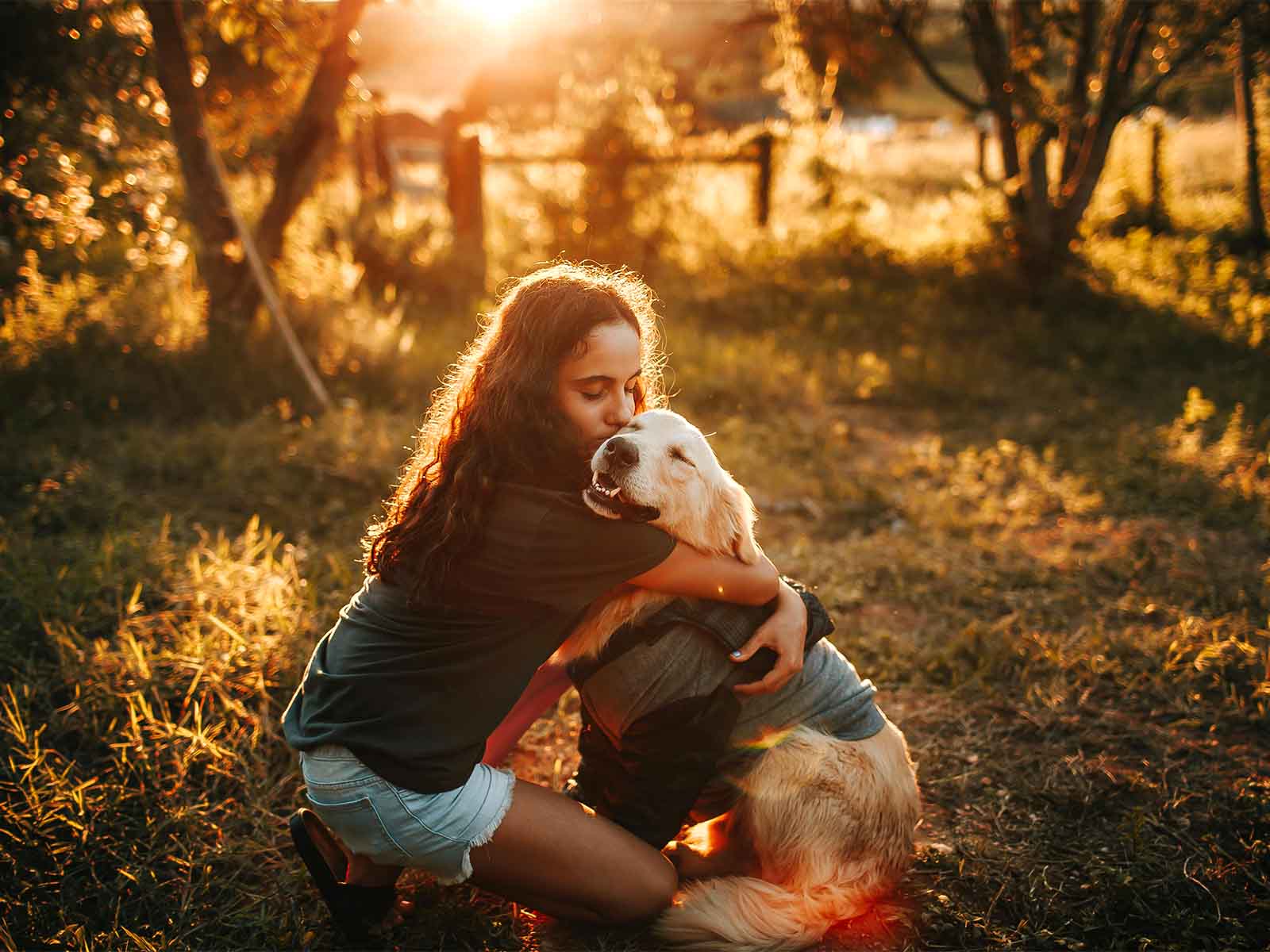 Niña abrazando a un perro golden retriever.