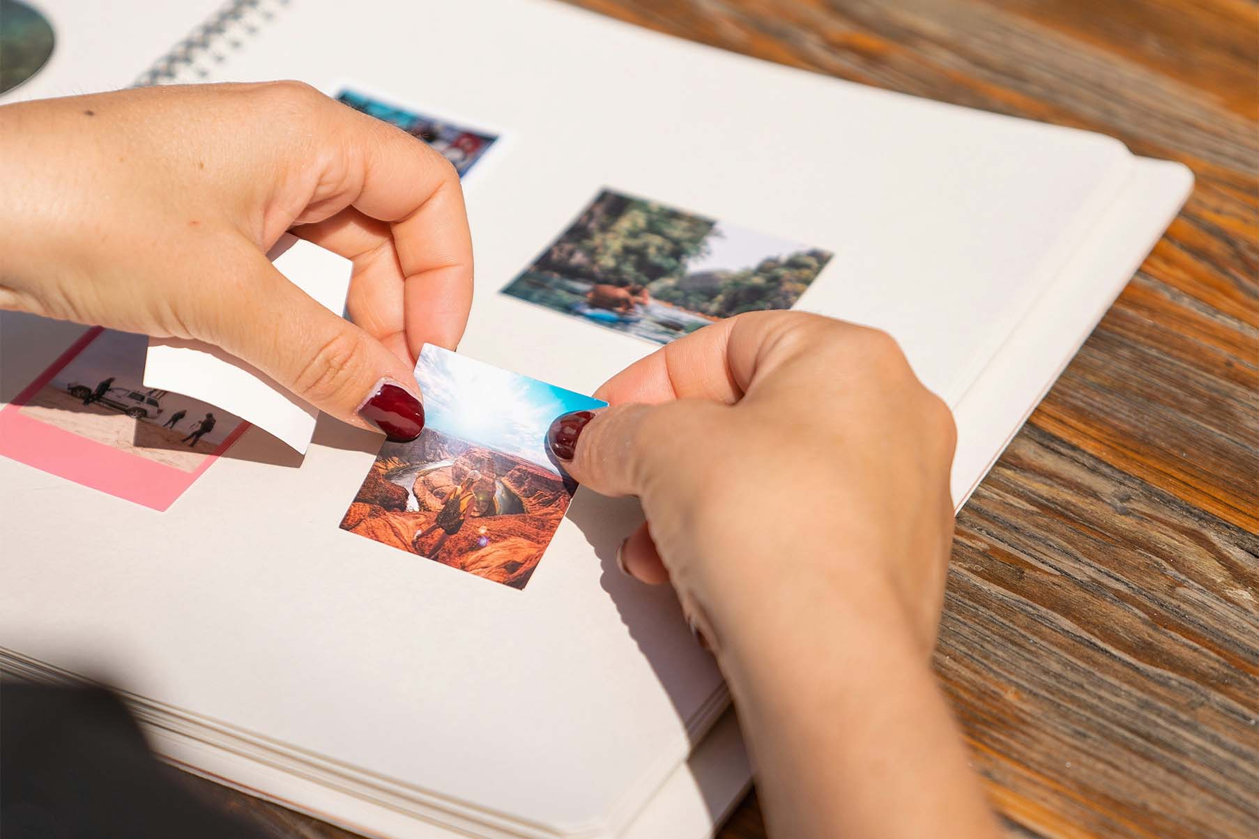 Manos pegando una foto en un álbum de fotos.